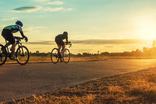 silhouette-group-men-riding-bicycle-sunset